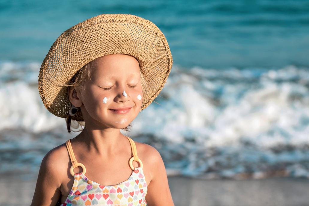 Dítě na pláži s SPF