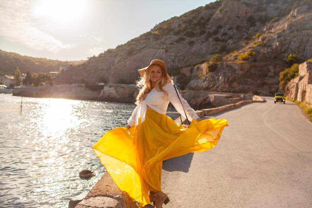 Žena v žluté sukni u vody