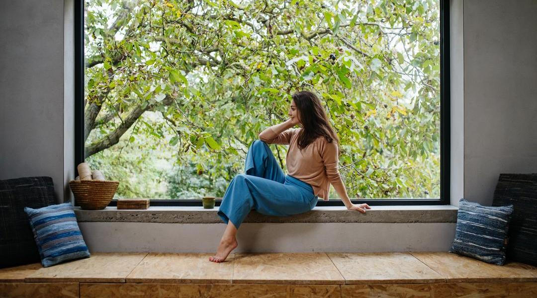 Žena v pohodlném oblečení u okna