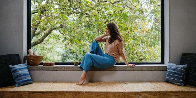 Žena v pohodlném oblečení u okna