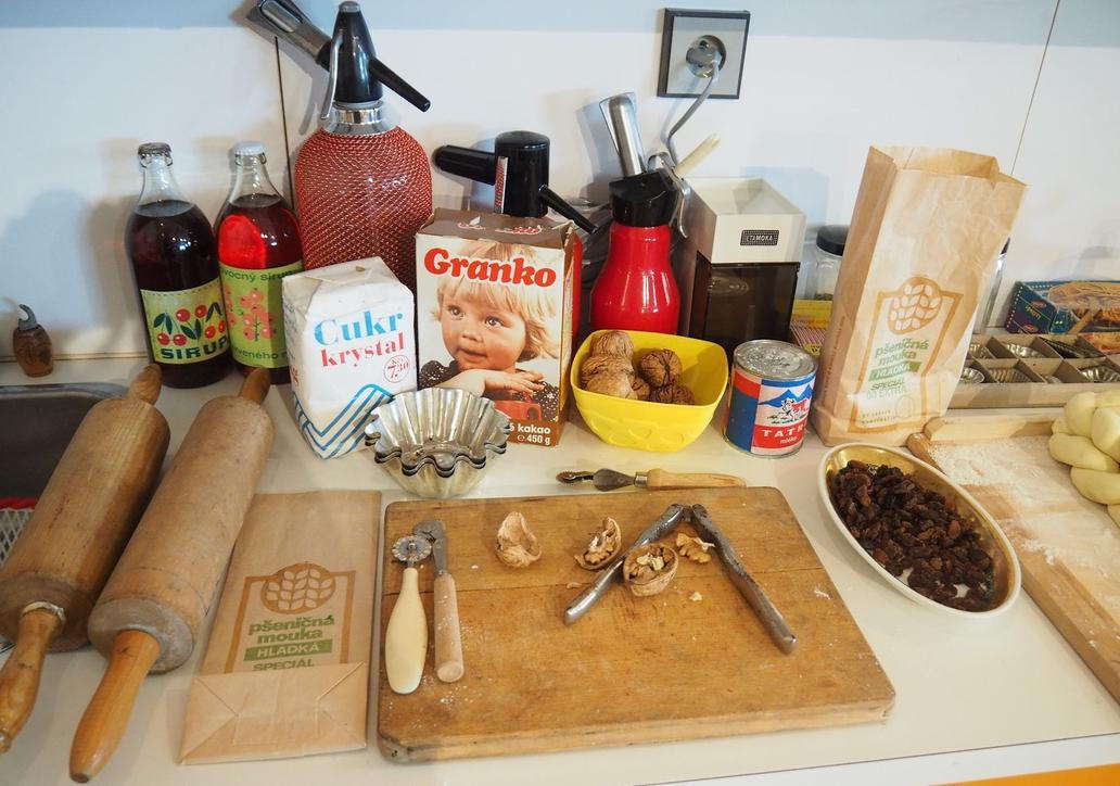 Na kuchyňské lince si pamětníci jistě všimnou bombičkové lahve na sodovku (ta větší), bombičkové lahve na šlehačku (ta malá červená) nebo holčičky na krabičce kakaa Granko.