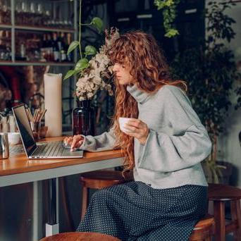 Žena v kavárně s počítačem