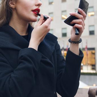 Žena si nanáší rtěnku