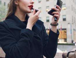 Žena si nanáší rtěnku