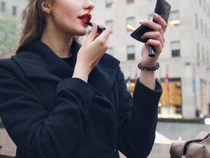 Žena si nanáší rtěnku