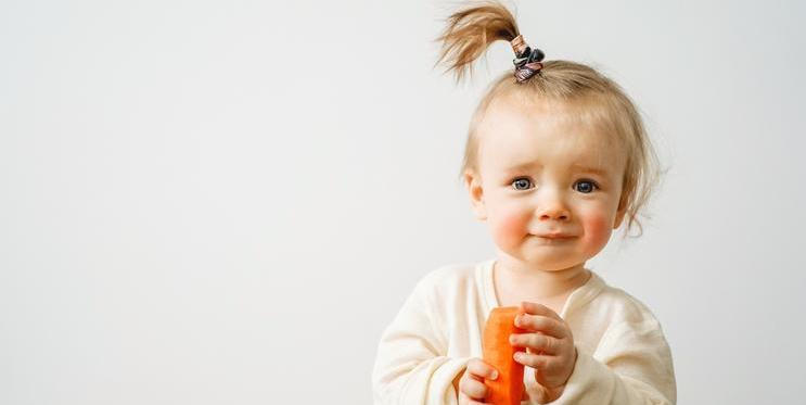 A,Baby,With,A,Food,Allergy,Holds,A,Carrot,In