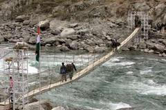 První lidé přecházejí most.