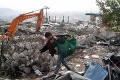 Muž si v troskách Muzaffarábádu nese svoje osobní věci