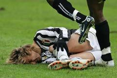 Pavel Nedvěd z Juventusu leží na trávníku po jednom z faulů soupeře.