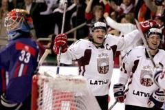 Lotyšští hokejisté Semjonovs a Tambijevs oslavují gól do slovinské sítě