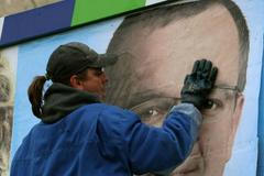 Pracovník firmy Europlakát připevňuje na reklamní plochu v pražské Libni billboard, kterým chce voliče zaujmout KDU-ČSL