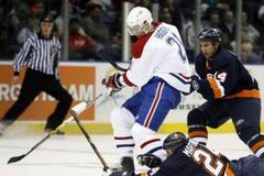 Obránci Islanders se snaží zastavit útočníka Higginse z Montrealu