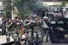 Vojáci se kryjí za obrněným transportérem