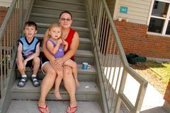 Mary Baker s dcerou a synem před svým domem