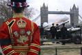 Londýnský Beefeater hledí na Tower Bridge