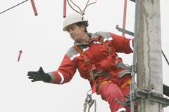 Opravář na sloupu elekrického vedení