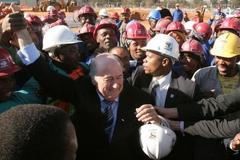 Sepp Blatter se zdraví s dělníky