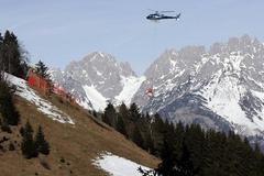 Vrtulník přepravuje sníh v Kitzbuehelu na sjezdovku