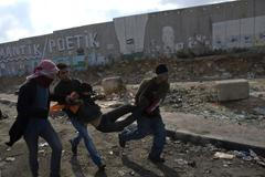 Palestinci v Gaze odnášejí zraněného chlapce