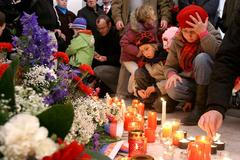 Děti zapalují svíčku u pomníku připomínající události 17.listopadu