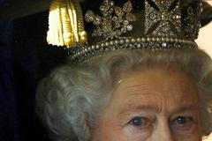 Královna Alžběta vyhlíží z kočáru