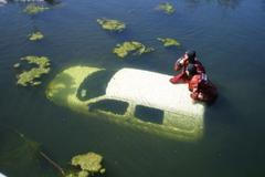 Hasiči vytahují vozidlo z rybníku