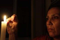 Žena zapaluje ve svém domě svíčku během výpadku elektřiny v Riu de Janeiru