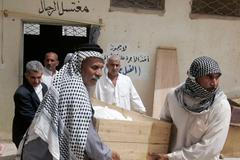 Iráčané odnášejí tělo jedné z obětí sebevražedného útoku, který se odehrál v Nadžáfu