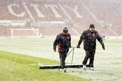 Zřízenci odklízejí sníh z fotbalového hřiště Stoke City