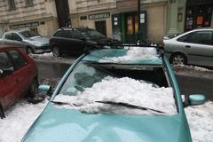 Auta poničená sněhem v pražské Hálkově ulici.