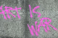 Nápis vandala na Husově pomníku v Praze.