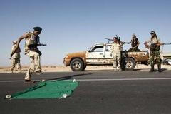 Libye - povstalec dupající po vlajce Kaddáfího