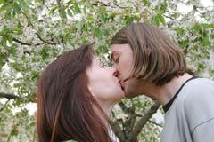 Pár líbající se pod rozkvetlou třešní