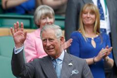 Princ Charles mává tenisovým fanouškům na Centr kurtu během utkání Rogera Federera a Fabia Fogniniho.