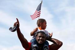 Sprinter Justin Gatlin slaví vítězství v závodu na 100 metrů během americké kvalifikace v Eugene 2012 se synem Jaceem.