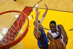 Mario Chalmers z Miami se prosazuje proti Nicku Collisonovi z Oklahoma City