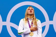 Litevská plavkyně Ruta Meilutyteová zpívá dojatě hymnu se zlatou medailí na krku za 100metrů prsařského závodu na OH 2012 v Londýně.