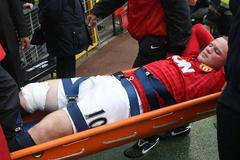 Zraněný Wayne Rooney opuští hřiště na stadionu Old Trafford