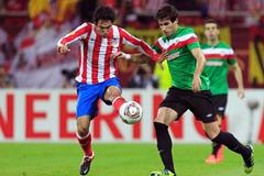 Arda Turan z Atlética Madrid bojuje o míč s Javi Martinezem z Athleticu Bilbao