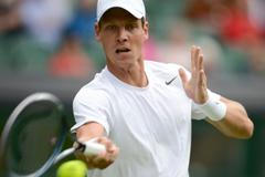 Český tenista Tomáš Berdych odráží míček během utkání s Lotyšem Ernestem Gulbisem v 1. kole Wimbledonu 2012