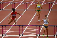 Česká překážkářka Zuzana Hejnová vítězí v 1. kole na 400 metrů překážek během OH 2012 v Londýně před Britkou T'ereou Brownovou.