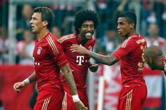 Hráči Bayernu Mnichov Mandžukič, Dante a Gustavo slaví gól do sítě Stuttgartu