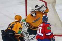 Hokejista Lva Praha Roman Červenka střílí na Antona Chudobina před Sandisem Ozolinšem v utkání KHL 2012/13 proti Atlantu Mytišči.,