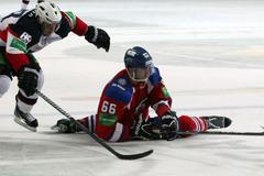 Hokejista Lva Praha Juraj Mikuš sedí před Milanem Kytnárem v utkání KHL 2012/13 proti Slovanu Bratislava.