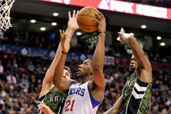 Thaddeus Young z Philadelphie se snaží probít proti Linasi Kleizovi a Amiru Johnsonovi z Toronta