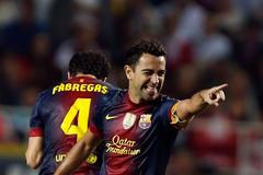 Fotbalista Barcelony Xavi Hernandez slaví gól Cesca Fabregase v utkání španělské La Ligy 2012/13 se Sevillou.