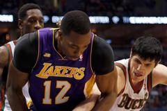 Basketbalista LA Lakers Dwight Howard se přetahuje o míč s Ersanem Ilyasovou z Milwaukee