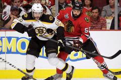 Bruins' Jagr is checked by Blackhawks' Bollig in double-over