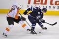 Pavel Kubina (Philadelphia Flyers) dotírá na Alexandra Burmistrova (Winnipeg Jets) v utkání NHL