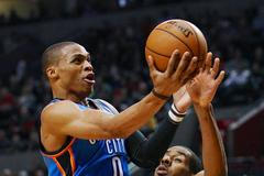 Basketbalista Russel Westbrook se snaží vystřelit přes LaMarcuse Aldridgeho v zápase Oklahomy s Portlandem